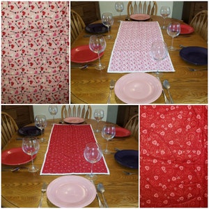 May include: Two table runners with a pink and red heart pattern. The table runners are on a wooden table with glasses and plates.
