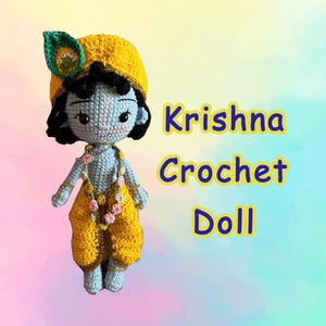 Könnte beinhalten: Eine hellblaue Häkelpuppe mit schwarzen Haaren, die eine gelbe Mütze mit einer Pfauenfeder und eine gelbe Hose trägt. Die Puppe hat eine Blumengirlande und der Text Krishna Crochet Doll ist in blauen Buchstaben mit gelbem Rand dargestellt.