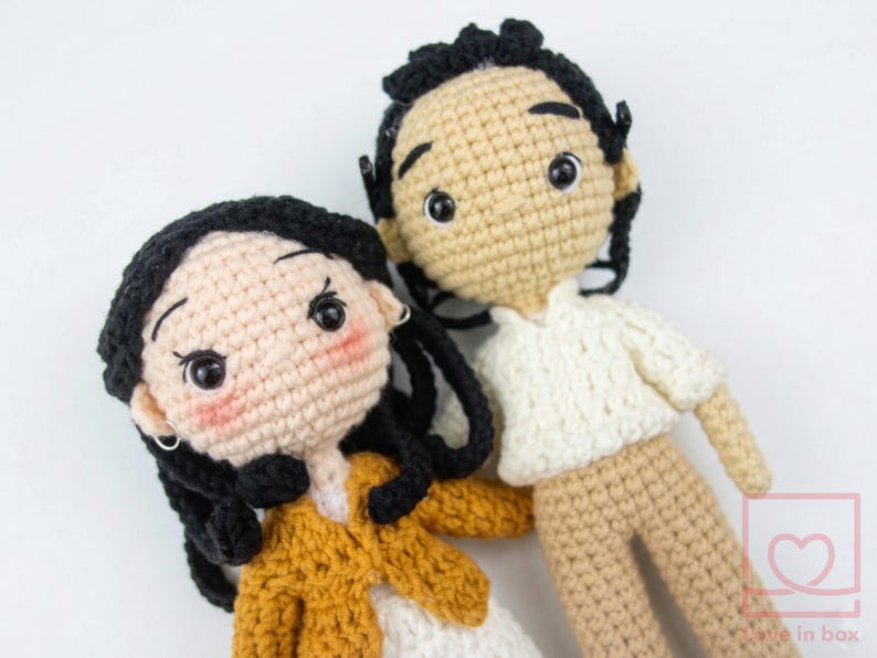 Custom amigurumi couple portrait dolls created from a photo, featuring a handmade miniature groom in a suit and bride in a white lace dress.