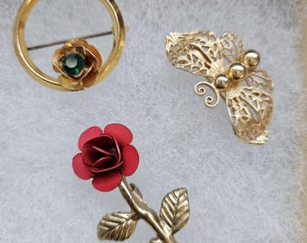 Conjunto de broches vintage: mariposa de los años 50 y 70, rosa roja y cristal verde.