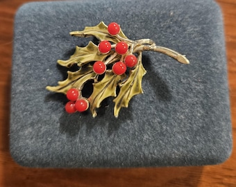 Broche vintage de los años 50, firmada por Piscitelli, en tono dorado, con bayas de acebo rojas y hojas verdes sombreadas.
