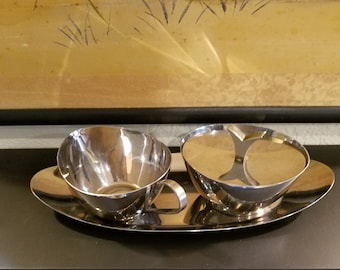 Juego de azucarero y lechera de acero inoxidable de la marca Riviera, estilo moderno de mediados de siglo, con bandeja para servir.