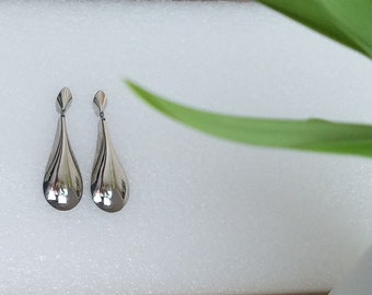 Unusual 1980s silver dangly earrings shaped like a raindrop will go with anything from an elegant evening dress to casual jeans or shorts.