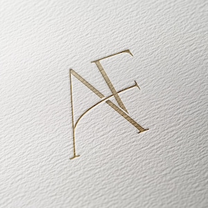 Puede incluir: Un logotipo de monograma con las letras "AF" en un estilo minimalista y moderno. Las letras están entrelazadas, creando un diseño único y elegante.
