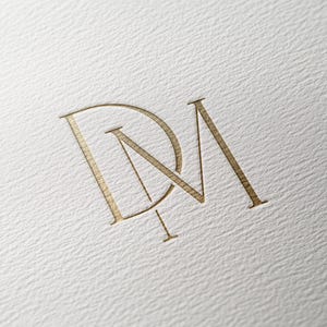 Könnte beinhalten: Ein goldenes Monogramm mit den ineinander verschlungenen Buchstaben "DM".