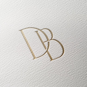 Könnte beinhalten: Ein goldfarbenes Monogramm-Logo mit den ineinander verschlungenen Buchstaben "DB".