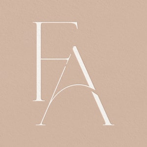 以下が含まれることがあります： 「FA」という文字が、モダンでミニマルなスタイルでデザインされた白いロゴ。文字は、ユニークな重なり合ったデザインでスタイリッシュに表現されています。
