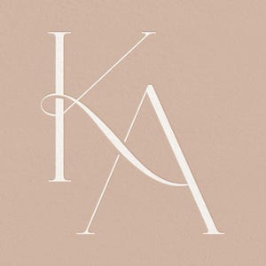 May include: White monogram featuring the letters "KA" intertwined. The letters are in a simple, elegant font.