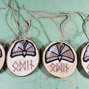 Hand-painted and lettered, 2-sided Odin Norse God Wood Slice Ornaments. Set of 4. Each includes 12&quot; long twine for hanging.