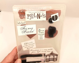 Peut inclure: Un étui en plastique transparent contenant divers tampons en caoutchouc avec des citations et des images sur le thème de l'amitié. Les tampons incluent des phrases comme "Friends", "For my Friend" et "A true friend touches your soul".