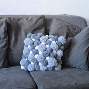 teal pom pom cushion