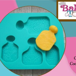 May include: A teal silicone mold with perfume bottle shapes and a yellow, perfume-shaped piece. The mold has detailed floral patterns. The image includes the text "Baker's Toybox" and "Check out our Coordinating Molds."