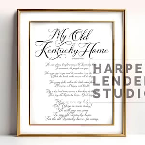 May include: A framed print of the song "My Old Kentucky Home" by Stephen Foster. The lyrics are printed in black cursive script on a white background. The frame is gold.