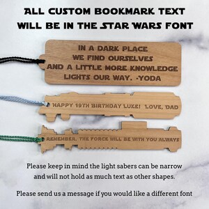 Op de afbeelding: Drie houten bladwijzers in de vorm van lichtzwaarden. De bovenste bladwijzer heeft de tekst "IN A DARK PLACE WE FIND OURSELVES AND A LITTLE MORE KNOWLEDGE LIGHTS OUR WAY. -YODA". De middelste bladwijzer heeft de tekst "HAPPY 19TH BIRTHDAY LUKE! LOVE, DAD". De onderste bladwijzer heeft de tekst "REMEMBER, THE FORCE WILL BE WITH YOU ALWAYS".