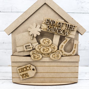 May include: Wooden craft project featuring a leprechaun's hat, a pot of gold coins, a horseshoe, and a shamrock. The sign reads "End of the Rainbow". The base of the project has a tag that reads "Lucky You".