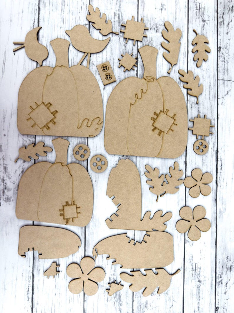 May include: A set of unfinished wooden craft cutouts featuring pumpkins, leaves, flowers, and buttons. The cutouts are perfect for fall-themed crafts and decorations.