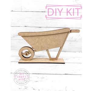 May include: A wooden DIY craft kit of a wheelbarrow. The wheelbarrow is made of unfinished wood and is ready to be painted or stained. The kit includes all the pieces needed to assemble the wheelbarrow. DIY WITH AMBER THE MAKERS MAP. DIY CRAFT KITS.