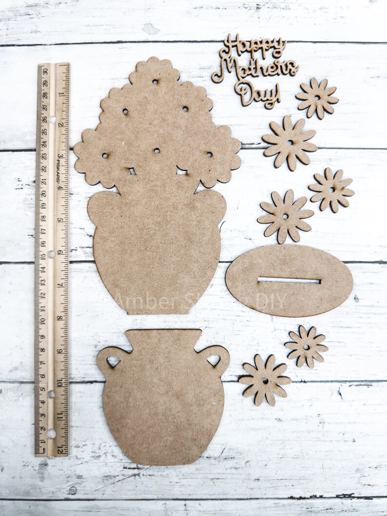 May include: Wooden craft kit for making a flower pot with flowers. The kit includes a vase, flowers, and a sign that says "Happy Mother's Day".