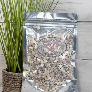 May include: A clear, resealable bag filled with small, light-colored decorative stones. The bag has a silver metallic finish and features the text "DIY WITH AMBER THE MAKERS MAP" in a circular design. A small potted plant is to the left.