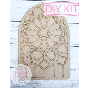 May include: DIY craft kit featuring a stained glass window design. The design is cut out of a light brown piece of wood. The kit includes all the materials needed to create a beautiful stained glass window.