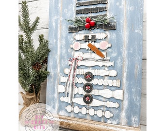 Peut inclure: Un kit de bricolage en bois pour faire un bonhomme de neige sur fond bleu. Le bonhomme de neige est composé de pièces en bois, dont un chapeau, une écharpe et des boutons. Le kit comprend un petit support en bois.