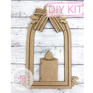 May include: DIY craft kit to make a wooden lantern with a candle. The lantern has a bow at the top and a cutout design. The kit includes all the pieces needed to assemble the lantern.