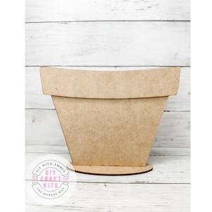 May include: A plain, unfinished wooden planter with a rounded top and a flat base. The planter is made of MDF and is ready to be painted or stained. The planter is a DIY craft kit from The Makers Map.