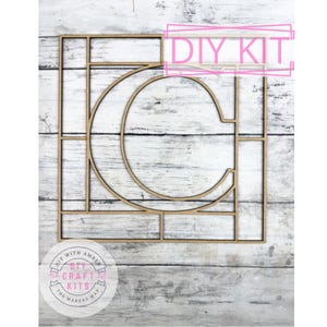 May include: A wooden DIY kit featuring the letter "C" within a geometric frame. The kit includes the text "DIY KIT" and a circular logo with the text "DIY WITH AMBER" and "DIY CRAFT KITS THE MAKERS MAP".