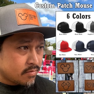 May include: A grey, black and white trucker hat with a brown leather patch featuring a Mickey Mouse silhouette and the text "Smith Family Disney Trip 2024". The hat is shown on a person's head. Six different colour combinations of the hat are shown below the main image.