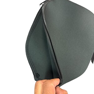 May include: A black zippered laptop sleeve with a soft, padded interior. The sleeve is open and the zipper is visible.