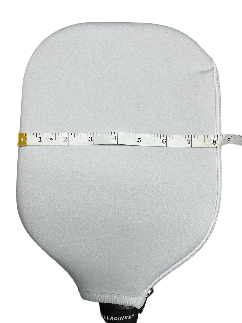 May include: White paddle cover with a zipper closure. The cover is 17.8 cm wide.