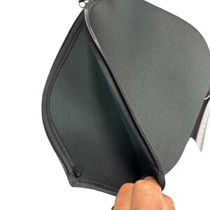 May include: Black zippered laptop sleeve with a soft, padded interior. The sleeve is open and the lining is visible.