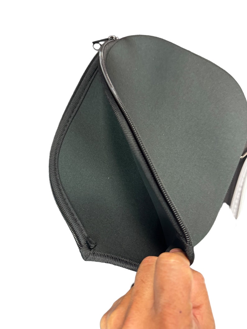 May include: Black zippered laptop sleeve with a soft, padded interior. The sleeve is open and the lining is visible.