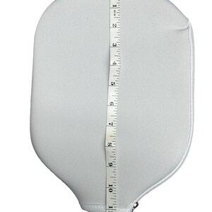 May include: White paddle with a black handle and a zipped pocket. The paddle is 12 inches long.