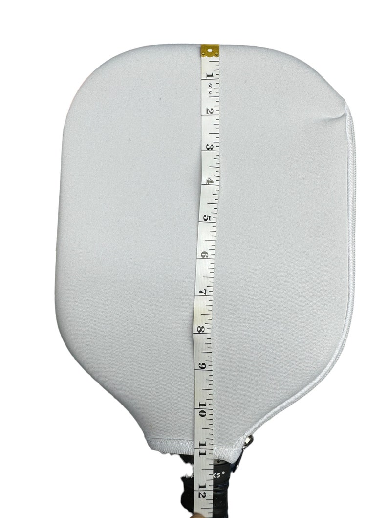 May include: White paddle with a black handle and a zipped pocket. The paddle is 12 inches long.