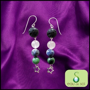 Peut inclure: Une paire de boucles d'oreilles en argent avec des perles de roche volcanique noire, blanches, bleues et vertes, et des breloques en forme d'étoile argentées.