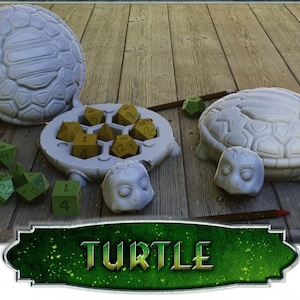 May include: A white turtle-shaped dice tray with a lid. The tray has a honeycomb design and holds multiple dice. The dice are green and gold. The word "TURTLE" is written in green letters on a sign.