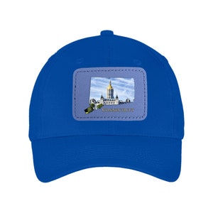 May include: A royal blue baseball cap with a grey patch featuring the outline of the state of Connecticut and a picture of the state capitol building. The patch also includes the word "CONNECTICUT" in gold lettering.