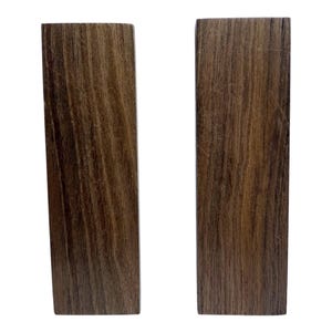 May include: Two dark brown wooden blocks with a wood grain pattern.