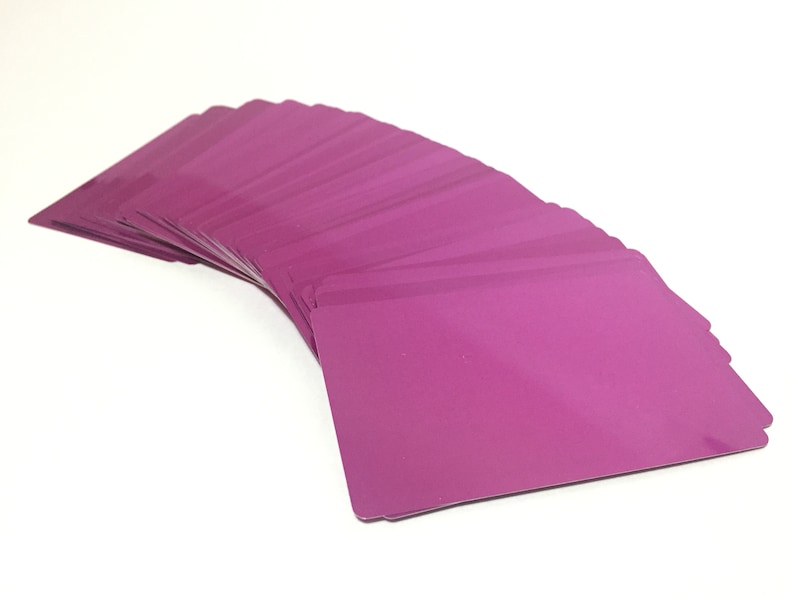 May include: A stack of blank, magenta-colored plastic cards fanned out in a semi-circle.