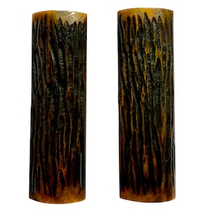 May include: Two brown and black cylindrical wooden handles with a wood grain pattern.