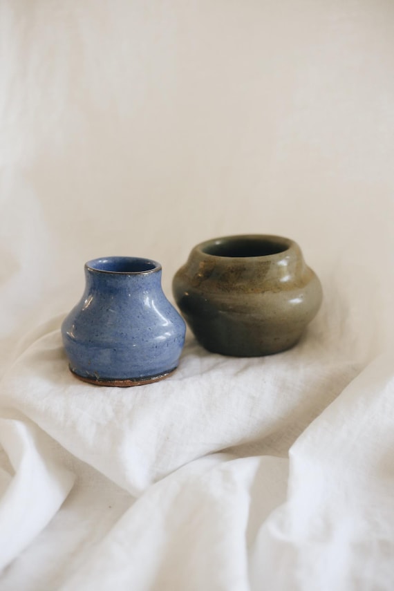 A matched pair of small wheel-thrown stoneware vases — the kind of tactile, imperfect-in-the-best-way pottery you'd spot in a boutique and immediately want.