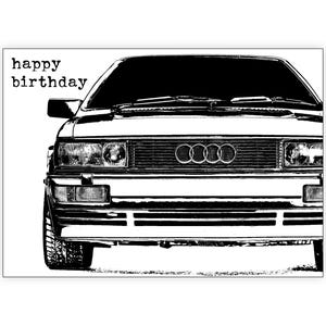 May include: A monochrome illustration of a vintage Audi car, featuring the text "happy birthday". The image highlights the front of the vehicle, displaying the headlights, grille, and the Audi emblem.