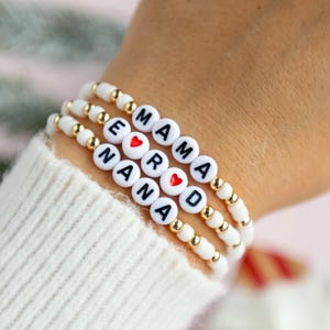 Pulseira de contas brancas personalizada SNOWFLAKE com detalhes em contas douradas plissadas.