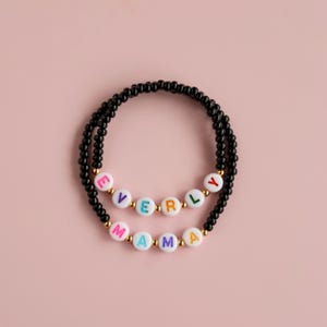Pulseira personalizada com contas coloridas e miçangas de vidro pretas.