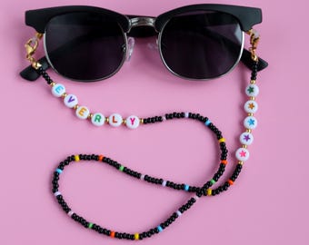 Chaîne de lunettes en perles avec nom et étoiles colorées.