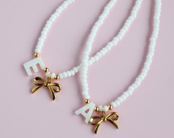 Initiaalketting met strikbedel.