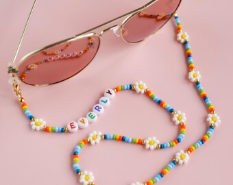 Gepersonaliseerde brilketting met kleurrijke regenboogkralen en kralenbloemen.