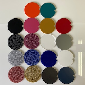 May include: Assortment of 16 round coasters in various colors and textures, including solid colors, glitter, and plain white. The coasters are arranged in a grid pattern.