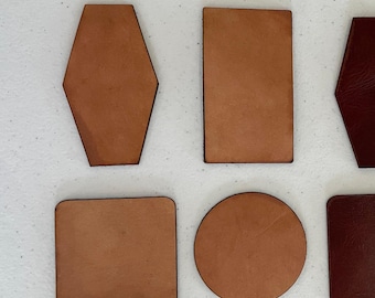May include: A collection of smooth, flat leather pieces in various geometric shapes including a hexagon, a rectangle, a square, and a circle. The pieces are rendered in shades of tan, light brown, and dark reddish-brown with visible grain.